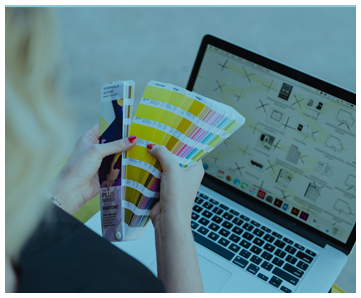 lady sitting with laptop and looking through colour swatches in her hands